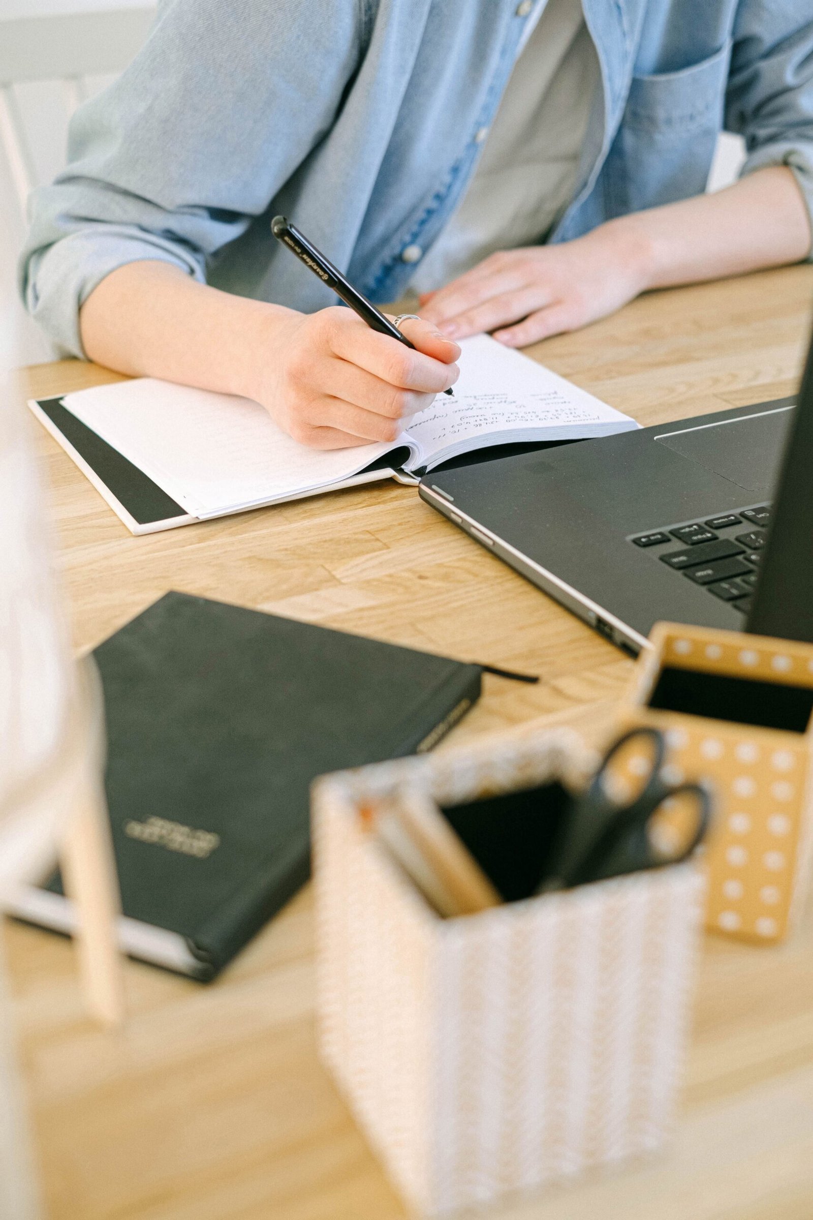 Writer taking notes while working on a laptop